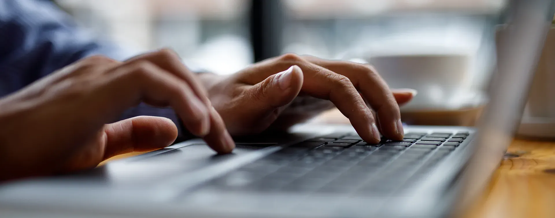 Person arbeitet an einem Laptop mit Programmcode für digitale Immobilienverwaltungssoftware.